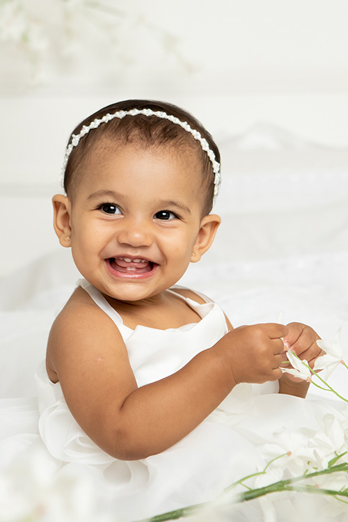 fotografia do ensaio dia das mãe, a criança bebe sorrindo na foto no estudio em betim contagem bh