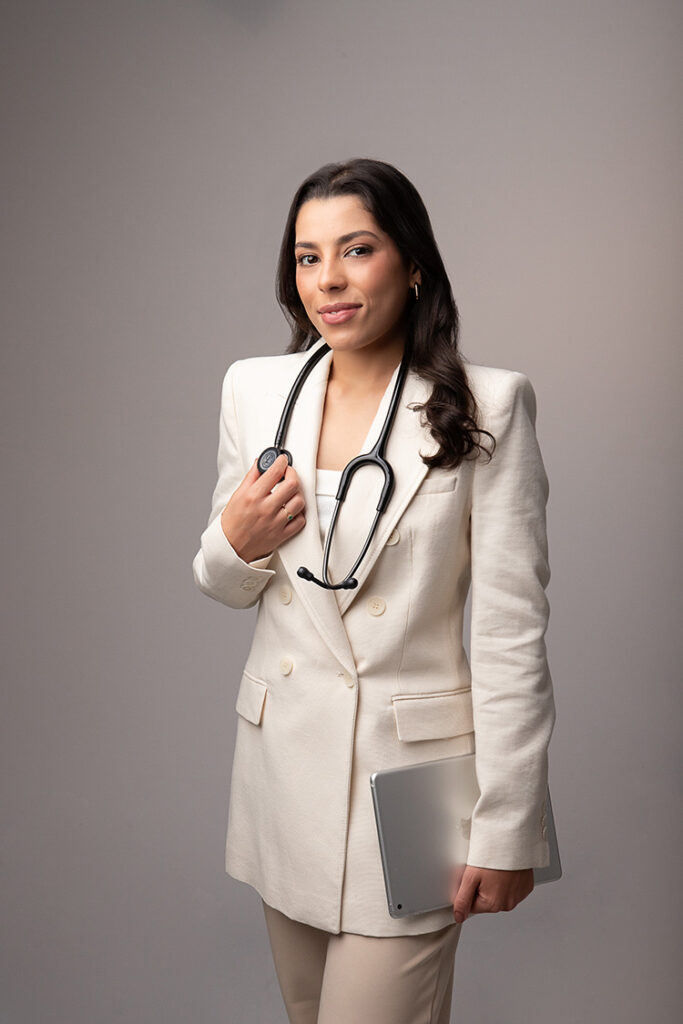 Profissional de branding com estetoscópio, vestida elegantemente, segurando um laptop, pronta para s.